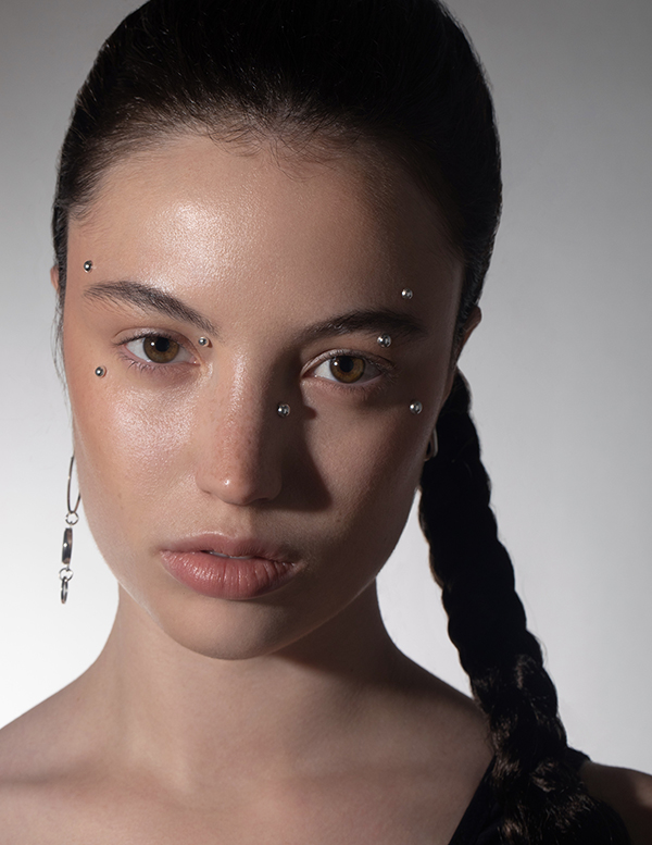 Professional studio portrait for a girl with dark hair and fake piercing