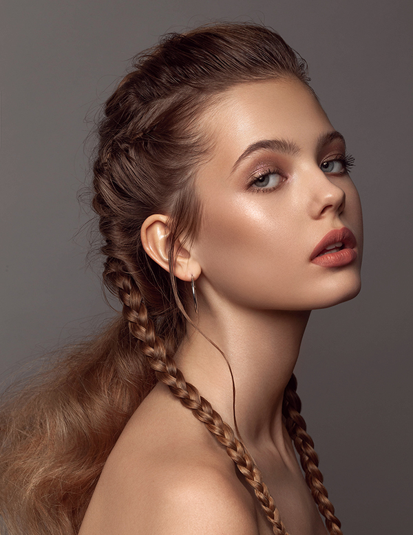 Creative braids as a hairstyle for professional retouched portrait in studio