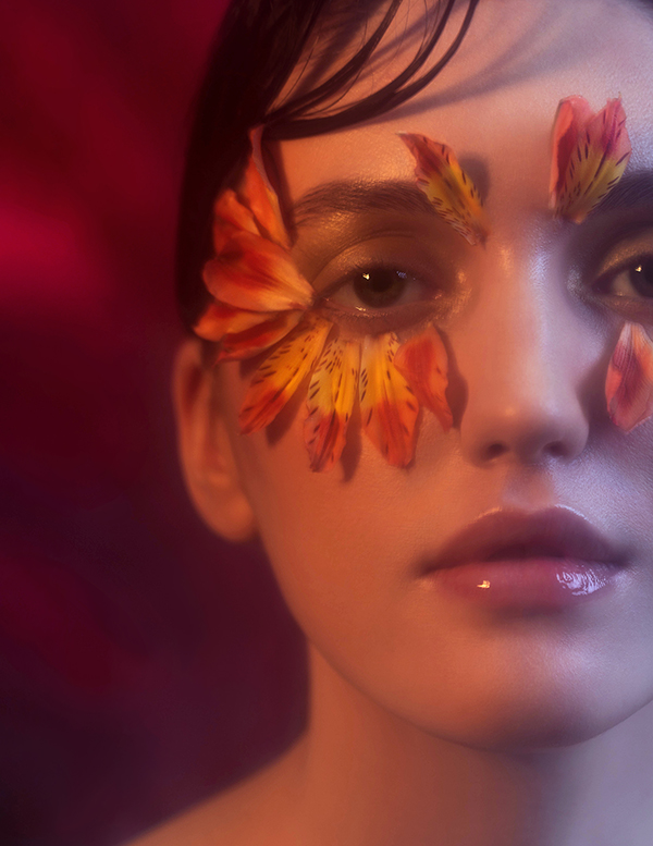 Portrait with flowers on the face of model in haze